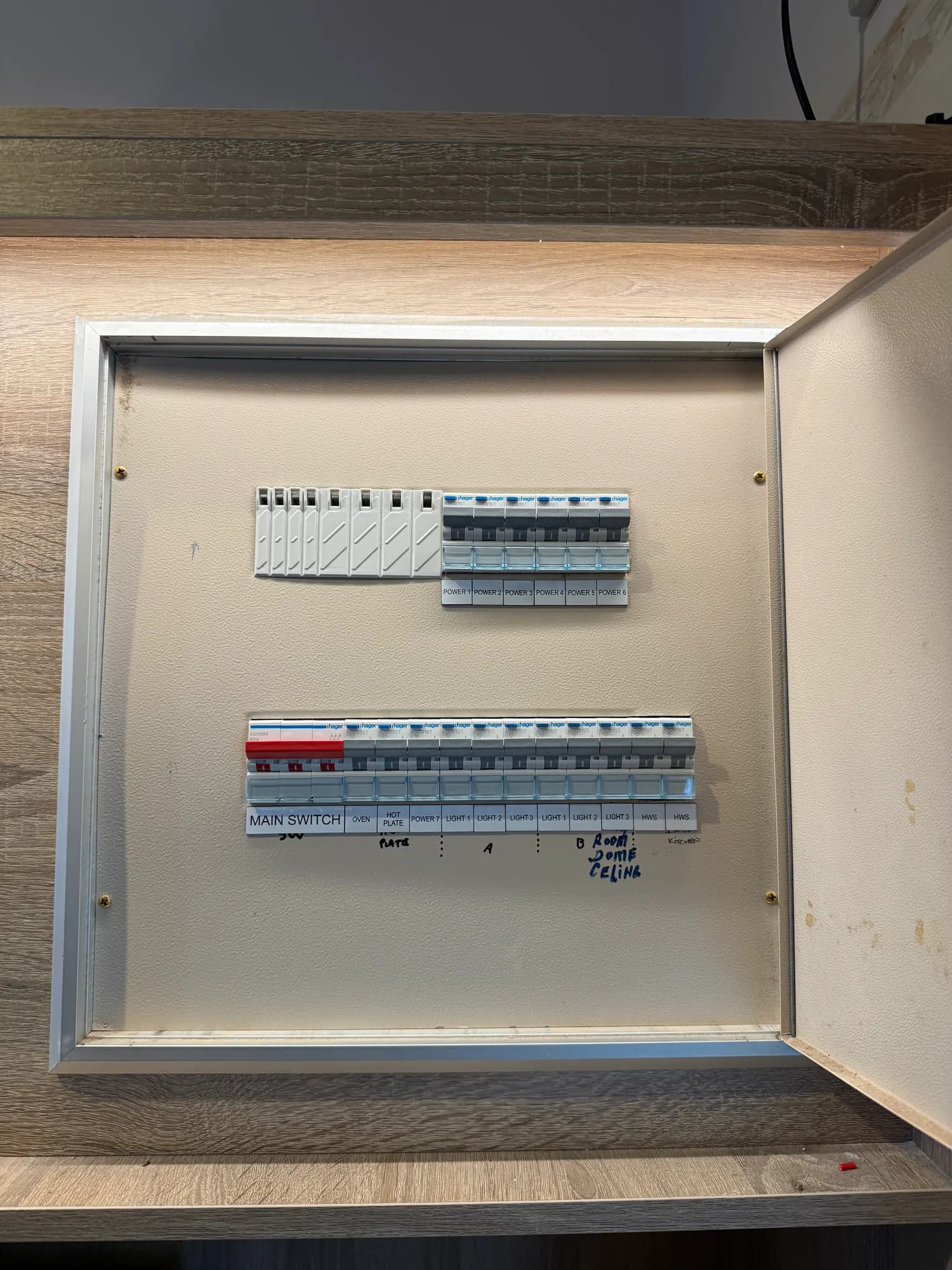 The finished board in the same cabinet: Hager devices with printed circuit labels