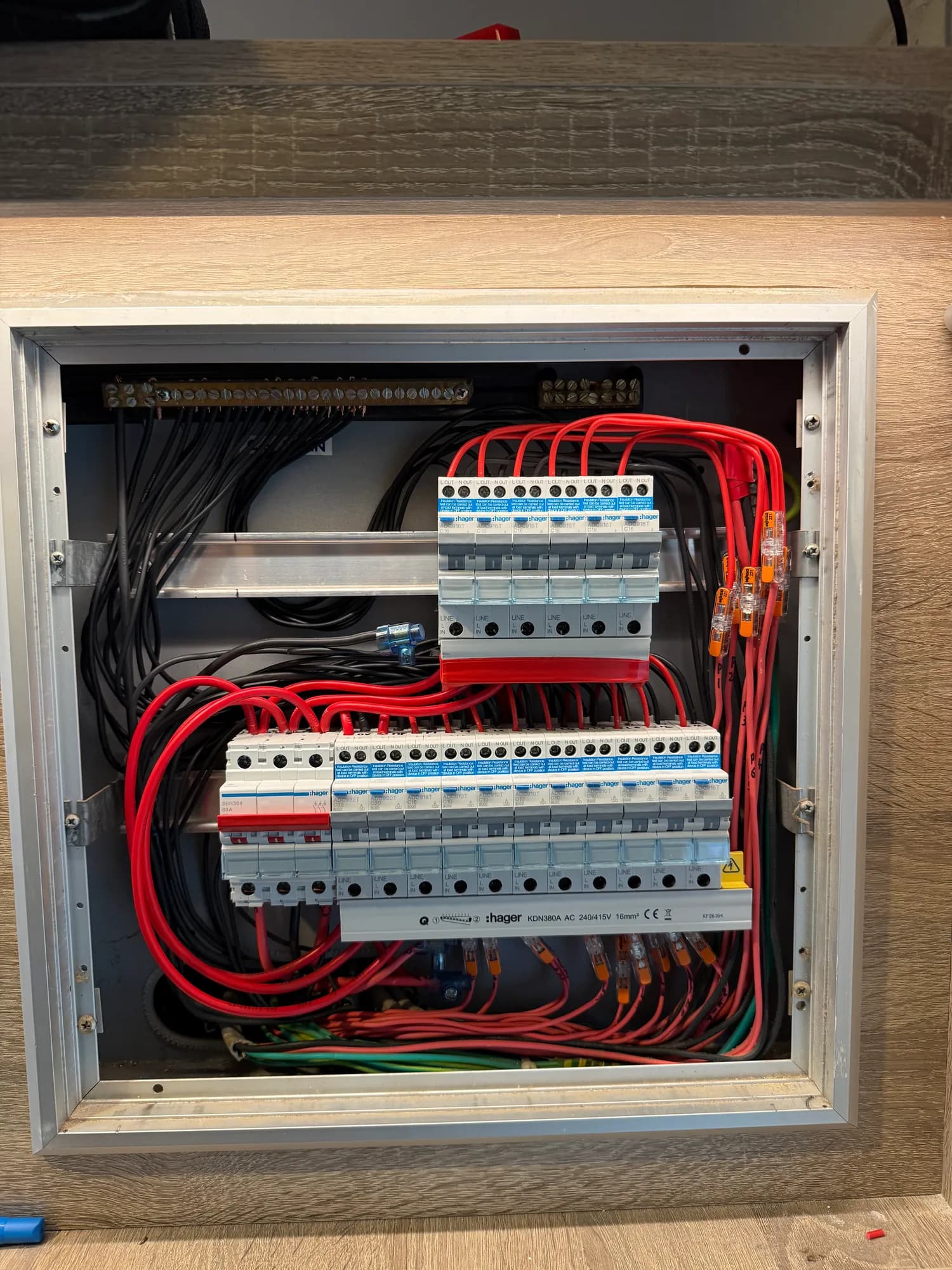 An older board in a wall cabinet rebuilt in place. The old Clipsal safety switch and Martec breakers came out, Hager RCBOs went in with the wiring dressed in neat runs, and the board was finished with printed circuit labels.
