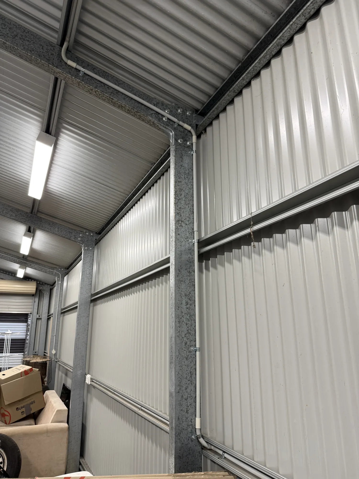 Neat conduit runs along shed ceiling with LED lighting